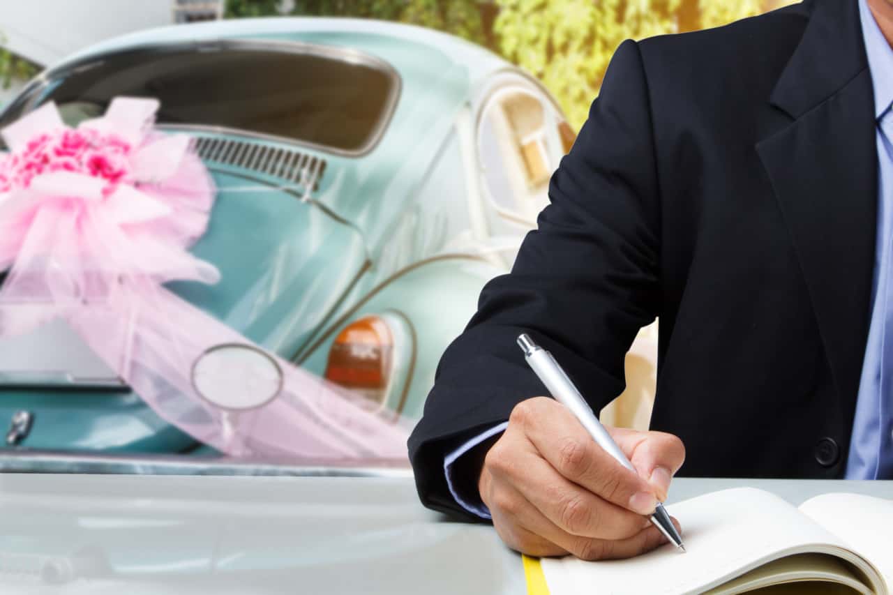 Photo of wedding supplier signing paperwork at a wedding venue